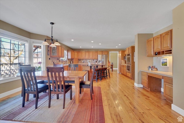 243 Eastridge E, Logan, UT 84321 - dining space with light wood finished floors, built in desk, and baseboards