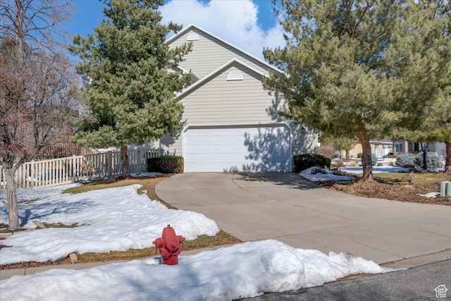 243 Eastridge E, Logan, UT 84321 - view of front facade featuring a garage, driveway, and fence
