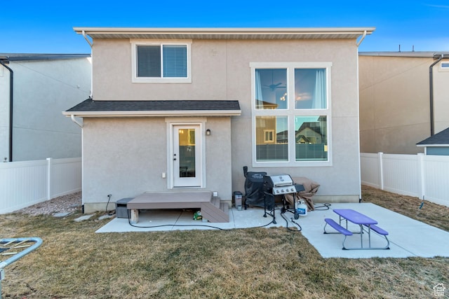 back of property featuring a patio, a lawn, fence private yard, and stucco siding
