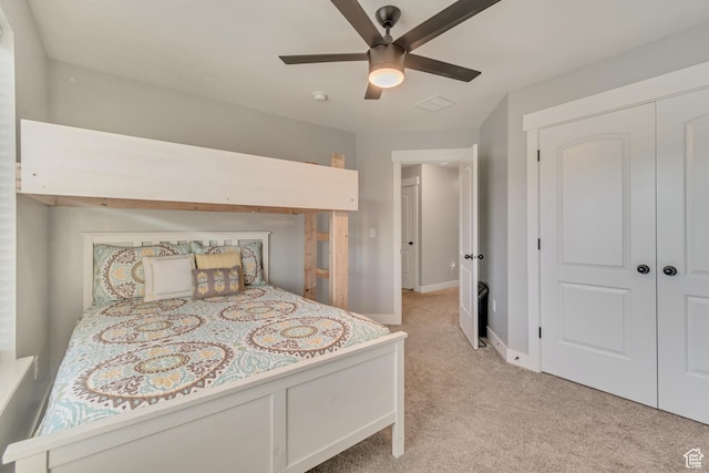bedroom with ceiling fan, light carpet, visible vents, baseboards, and a closet