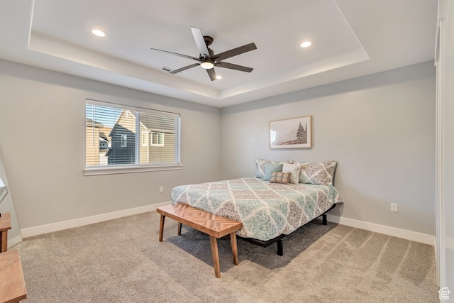 carpeted bedroom with baseboards, a tray ceiling, and recessed lighting