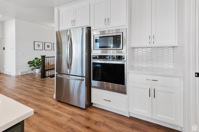 kitchen with white cabinets, visible vents, appliances with stainless steel finishes, and light countertops