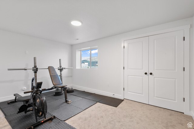 workout room featuring carpet and baseboards