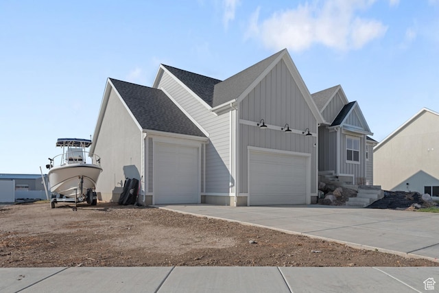 view of front of house featuring a garage, concrete driveway, roof with shingles, and board and batten siding