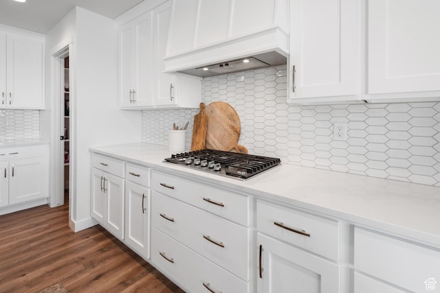 kitchen with light countertops, premium range hood, white cabinets, and stainless steel gas stovetop