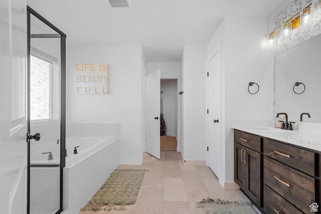 bathroom with visible vents, baseboards, a garden tub, tile patterned flooring, and vanity
