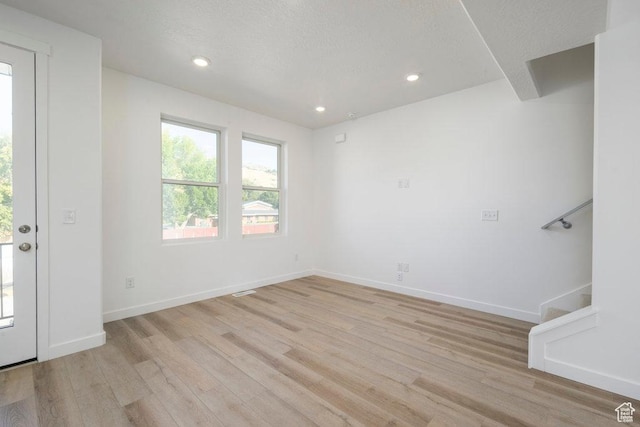 277 W 430 N Unit 1-03, Salt Lake City, UT 84103 - spare room featuring light wood-style floors, recessed lighting, stairs, baseboards, and a textured ceiling
