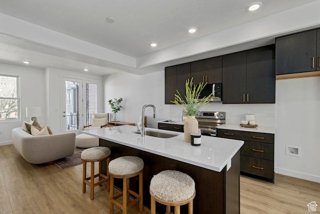277 W 430 N Unit 1-03, Salt Lake City, UT 84103 - kitchen featuring a sink, a kitchen bar, appliances with stainless steel finishes, light wood finished floors, and light countertops