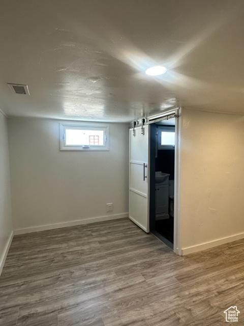 143 N 150 W, Tooele, UT 84074 - basement featuring a barn door, visible vents, baseboards, and wood finished floors