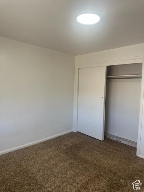 143 N 150 W, Tooele, UT 84074 - unfurnished bedroom featuring baseboards, dark colored carpet, and a closet