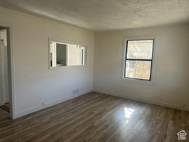 143 N 150 W, Tooele, UT 84074 - unfurnished room with dark wood-style flooring, visible vents, a textured ceiling, and baseboards