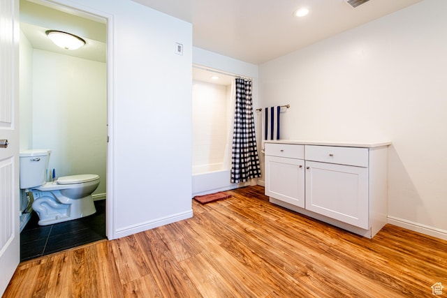 interior space with visible vents, wood finished floors, toilet, and baseboards