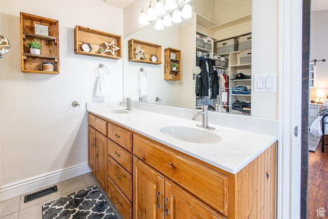 bathroom featuring double vanity, visible vents, a sink, and tile patterned floors