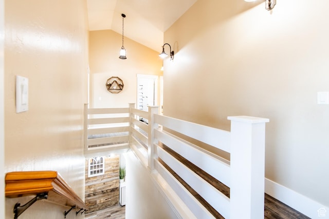 stairway with lofted ceiling, baseboards, and wood finished floors