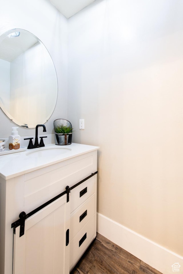 bathroom with wood finished floors, vanity, and baseboards