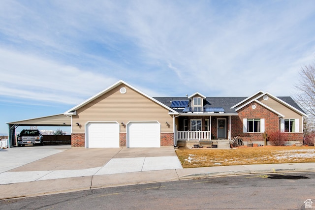 view of front of property featuring covered porch, solar panels, concrete driveway, and brick siding