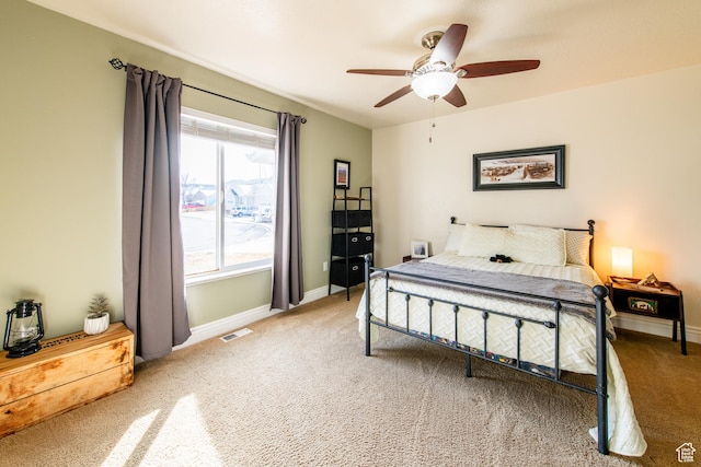 carpeted bedroom with a ceiling fan, visible vents, and baseboards
