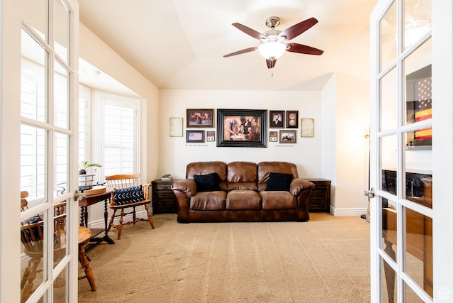 carpeted living area with french doors, a ceiling fan, and baseboards