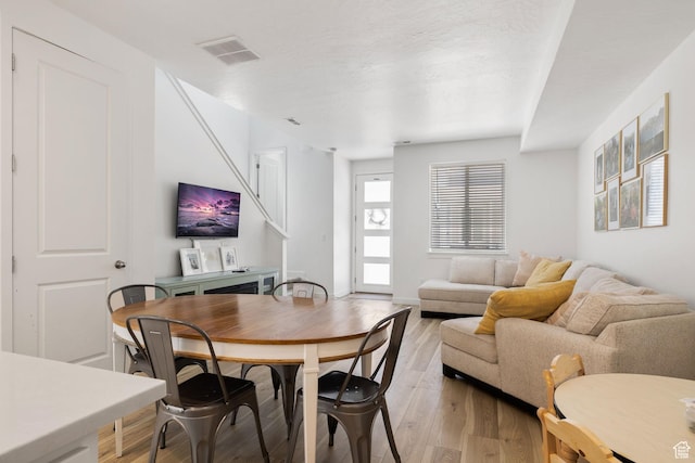 dining room featuring light wood-style flooring and visible vents