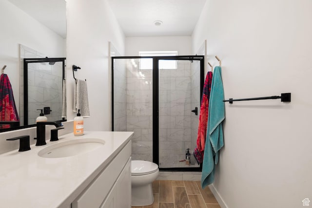 full bath with toilet, a shower stall, wood tiled floor, and vanity