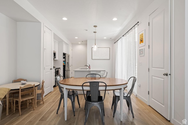 dining space featuring light wood-type flooring, baseboards, and recessed lighting