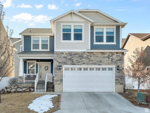 craftsman-style house featuring stone siding, concrete driveway, a porch, and an attached garage