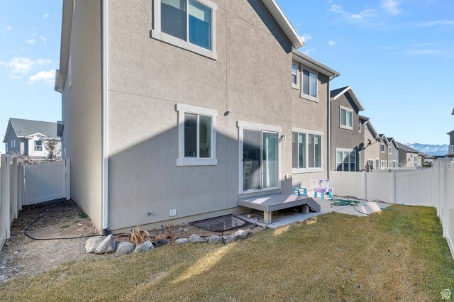 4927 W Yellow Topaz Dr, Herriman, UT 84096 - back of house featuring a fenced backyard, a yard, a residential view, stucco siding, and a patio area