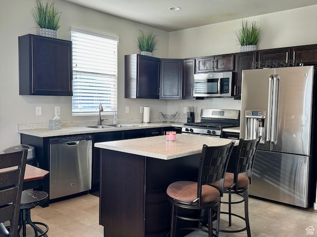 6583 W Annie Lee Way, West Jordan, UT 84081 - kitchen featuring a sink, a breakfast bar, stainless steel appliances, light countertops, and a kitchen island