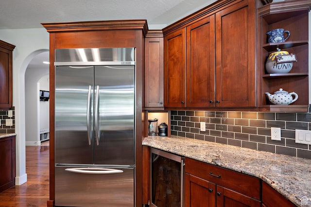 267 E Lucky Star Way, Farmington, UT 84025 - kitchen featuring built in refrigerator, beverage cooler, arched walkways, backsplash, and dark wood-type flooring