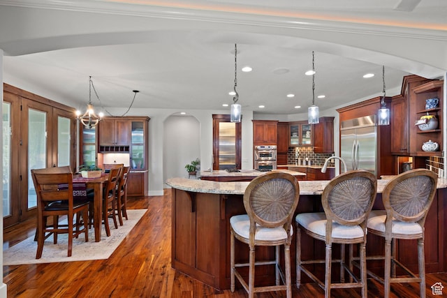 267 E Lucky Star Way, Farmington, UT 84025 - kitchen featuring appliances with stainless steel finishes, arched walkways, pendant lighting, a breakfast bar area, and recessed lighting