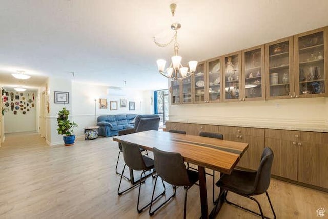 560 E S Temple N Pl 102, Salt Lake City, UT 84102 - dining space with light wood-style floors, a chandelier, and baseboards