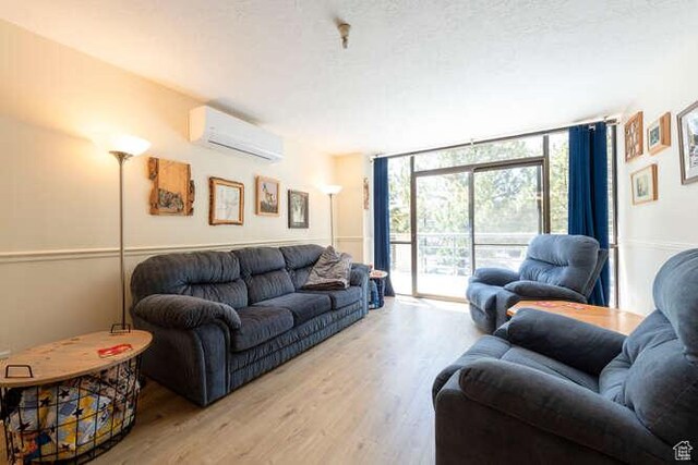 560 E S Temple N Pl 102, Salt Lake City, UT 84102 - living area featuring a wall mounted air conditioner, wood finished floors, and a wall of windows