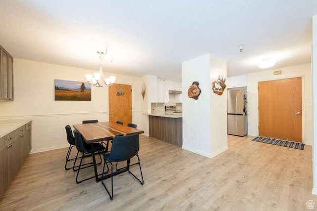 560 E S Temple N Pl 102, Salt Lake City, UT 84102 - dining area featuring light wood-type flooring, a chandelier, and baseboards