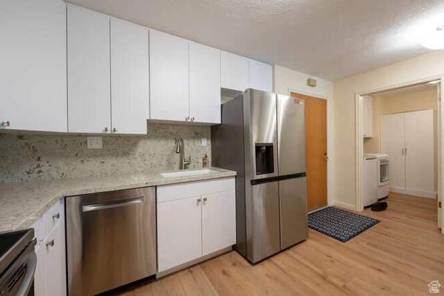 560 E S Temple N Pl 102, Salt Lake City, UT 84102 - kitchen featuring stainless steel appliances, a sink, light wood-type flooring, white cabinetry, and a textured ceiling