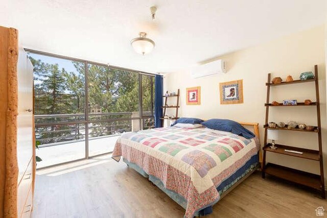 560 E S Temple N Pl 102, Salt Lake City, UT 84102 - bedroom featuring a wall unit AC, wood finished floors, expansive windows, and access to outside