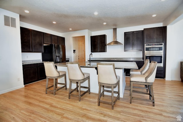 2292 N Elderberry Dr W, Saratoga Springs, UT 84045 - kitchen featuring visible vents, black refrigerator with ice dispenser, light wood-style flooring, a sink, and wall chimney range hood