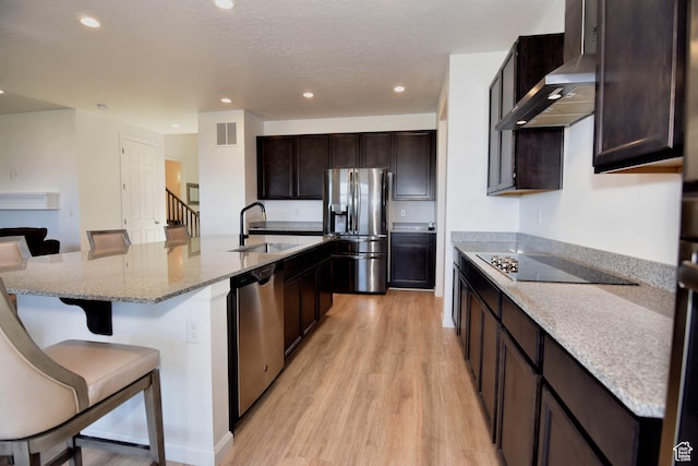 2292 N Elderberry Dr W, Saratoga Springs, UT 84045 - kitchen featuring stainless steel appliances, visible vents, light wood-style flooring, a sink, and wall chimney range hood