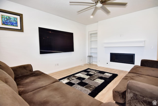 2292 N Elderberry Dr W, Saratoga Springs, UT 84045 - living room with a fireplace, wood finished floors, a ceiling fan, built in features, and baseboards