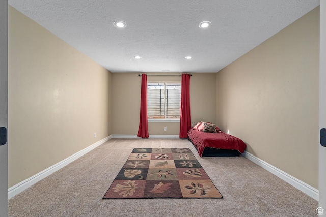 unfurnished bedroom featuring carpet flooring, a textured ceiling, recessed lighting, and baseboards