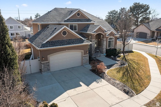 view of front of house featuring stone siding, stucco siding, a gate, concrete driveway, and fence