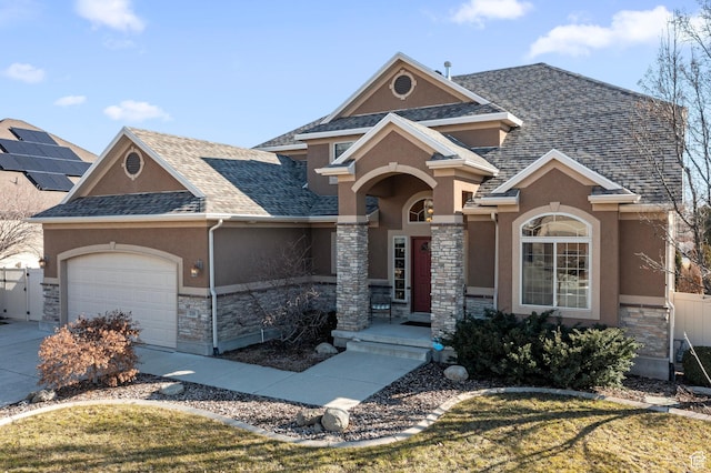 view of front facade with stone siding, stucco siding, roof with shingles, an attached garage, and driveway