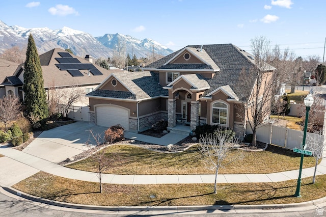 view of front of property with concrete driveway, fence, an attached garage, a gate, and a mountain view