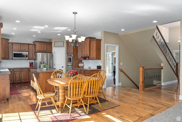 dining room with recessed lighting, wood finished floors, and a chandelier