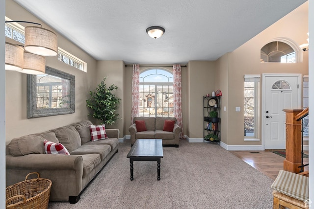carpeted living room with baseboards and a textured ceiling
