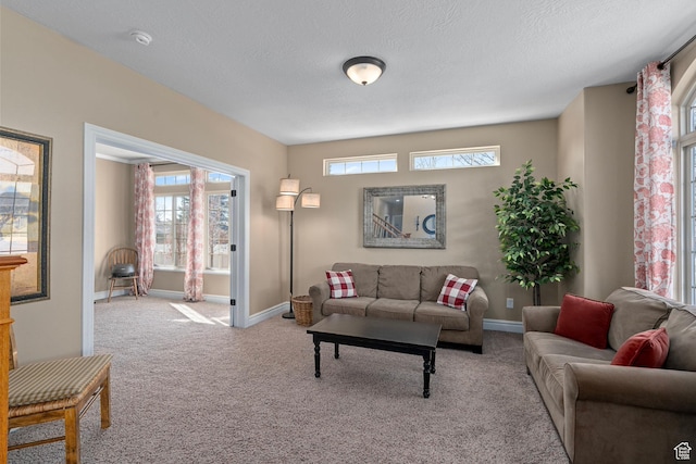 carpeted living room with baseboards and a textured ceiling
