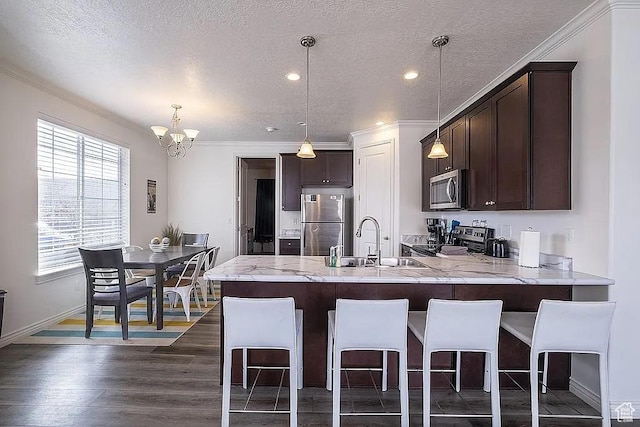 1042 W 500 S, Provo, UT 84601 - kitchen with dark brown cabinetry, a breakfast bar area, a peninsula, stainless steel appliances, and a sink