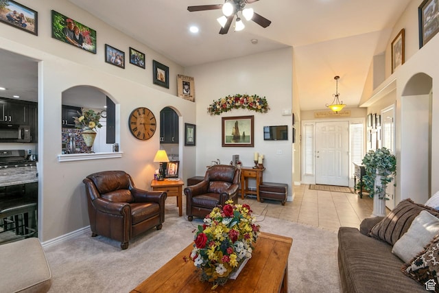 living room featuring a high ceiling, light tile patterned flooring, baseboards, and light carpet