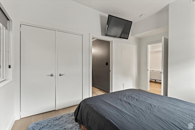 bedroom with light wood finished floors and a closet