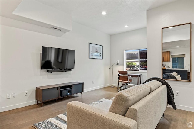 living area featuring recessed lighting, baseboards, and wood finished floors