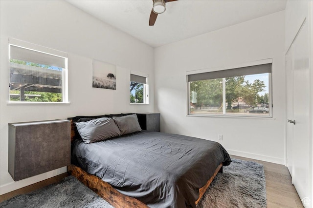 bedroom with a ceiling fan, baseboards, and wood finished floors
